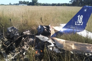 La avioneta Tecman estrellada, aún con llamas.