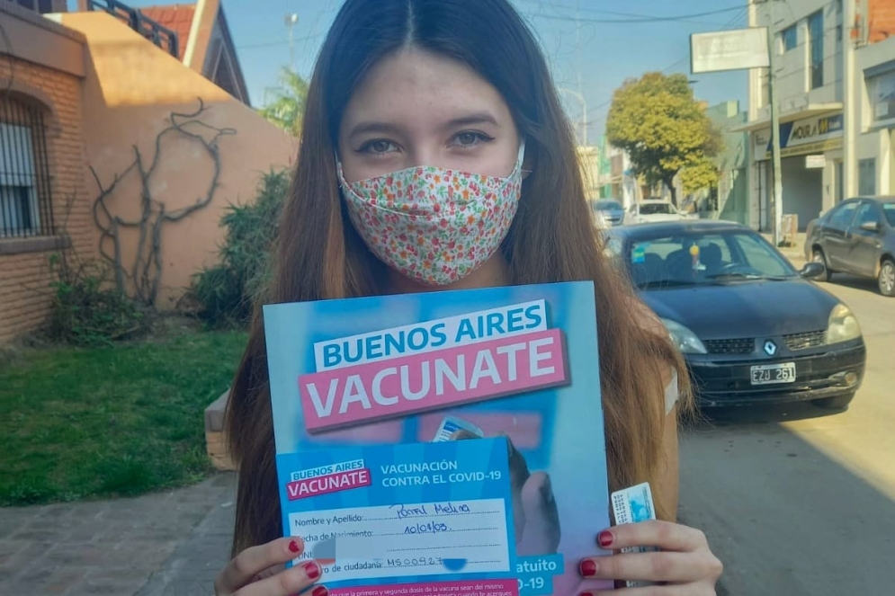 Melina osando con el certificado al salir del vacunatorio. 