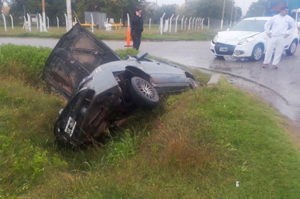 El Renault 19 quedó tumbado en la alcantarilla. 