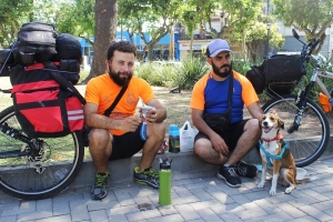 Los ciclistas Roberto y Guillermo descansan bajo la arbol&eacute;ada junto a Canela. 
