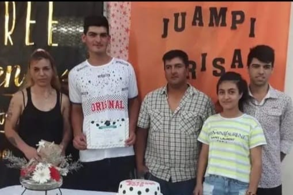 Alan con el diploma de egresado, junto a sus padres y hermanos. 