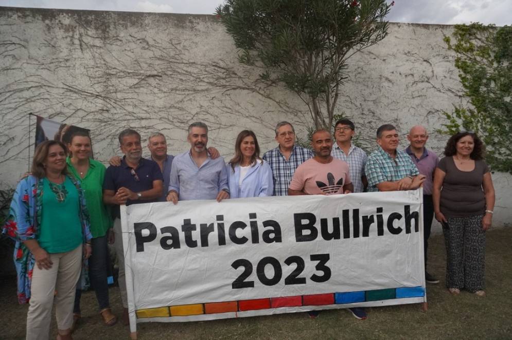 Un grupo de dirigentes posando con un banner de su candidata.